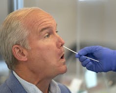 Conservative Leader Erin O’Tool in profile, being tested with a nasal swab