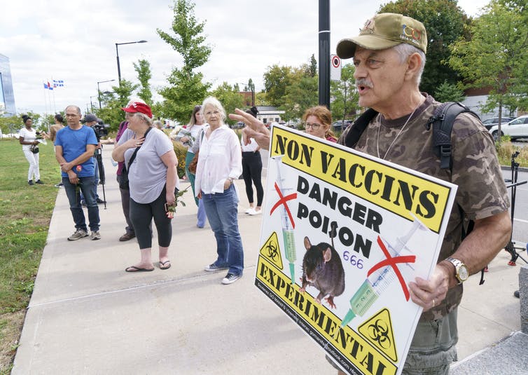 A man holds a sign