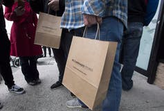 Brown paper shopping bags from the B.C. Cannabis Store carried by customers