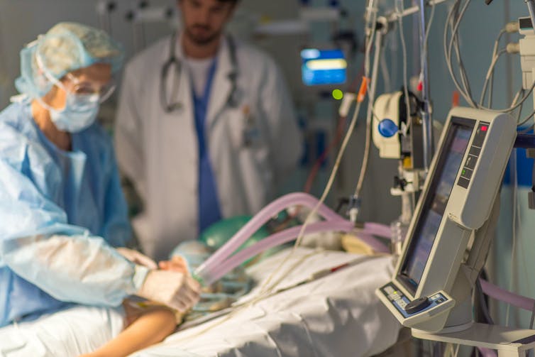Doctor providing breathing support for child in operating room.