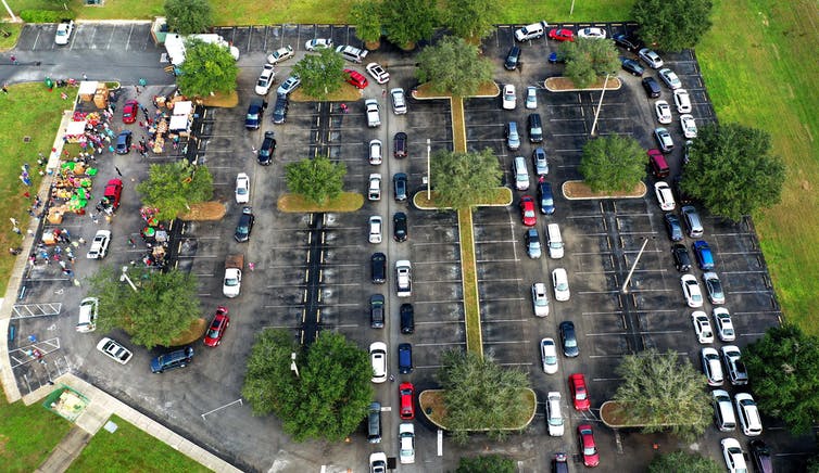 A long line of cars wraps around a parking lot