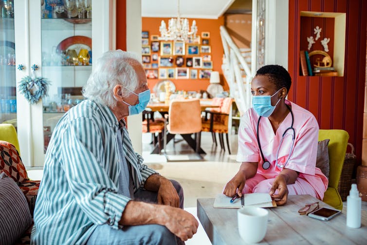Nurse talking to older adult in home