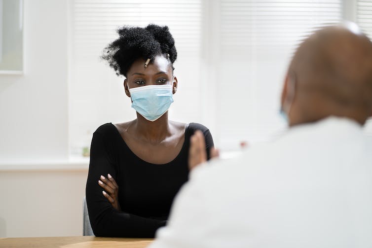 A woman wearing a mask with a doctor.