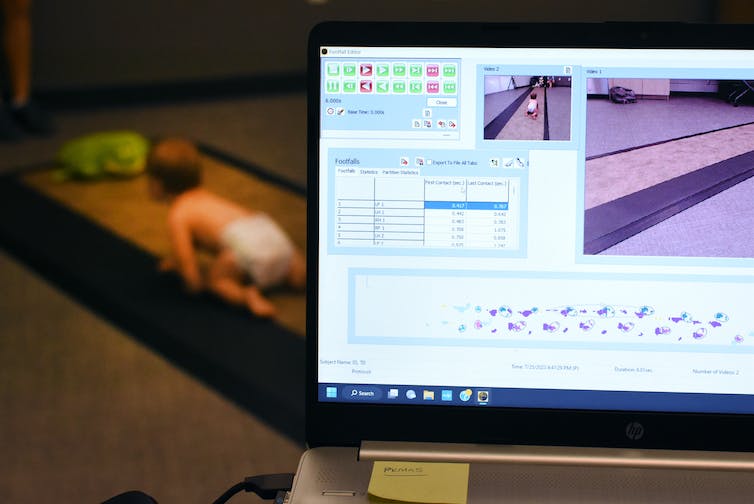baby crawling on a pathway in distance, with a computer readout of measurements of the baby's pressure on the path
