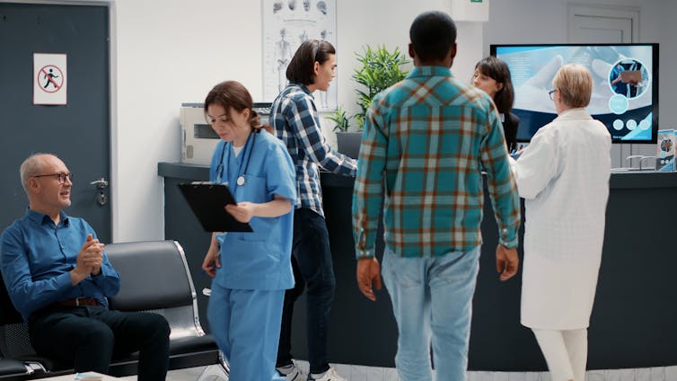 A nurse speaks with a patient in the waiting room.