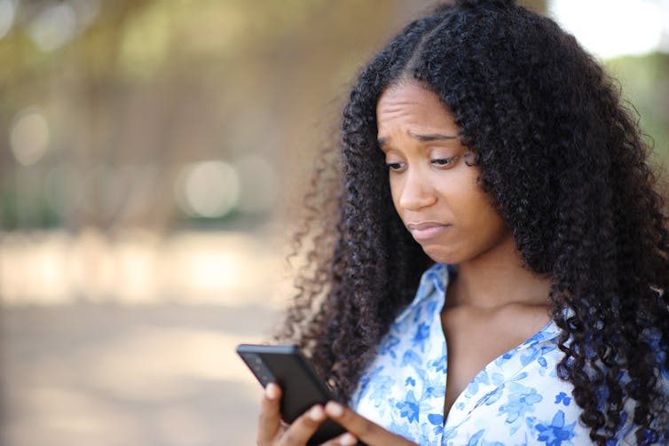 Sad woman looks at phone