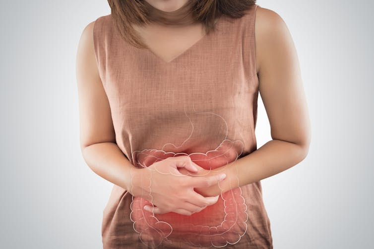 A woman with gut problems holds her stomach in pain.