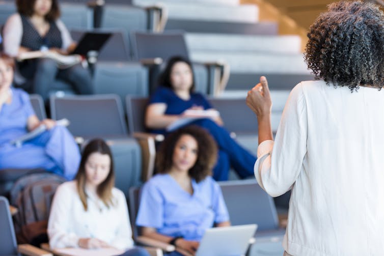 Health care provider lecturing to an audience of medical students