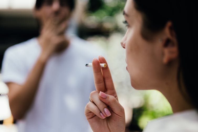 Young people smoking cigarettes.