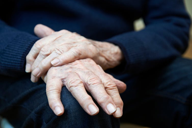 Close-up of folded hands of older adult