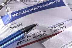 Pen, glasses and medicare health insurance card