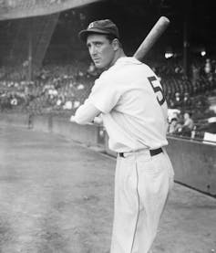 Wearing a Detroit Tigers uniform, Hank Greenberg poses for a photo holding his baseball bat.