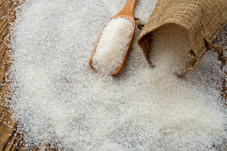 white sugar spilling out of brown bag