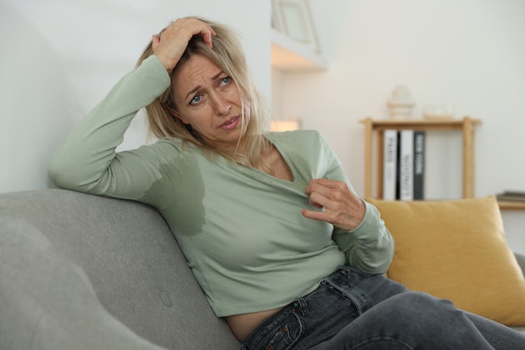 A woman sweats because of a hot flush.