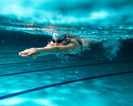Female swimmer at the swimming pool. Underwater photo.