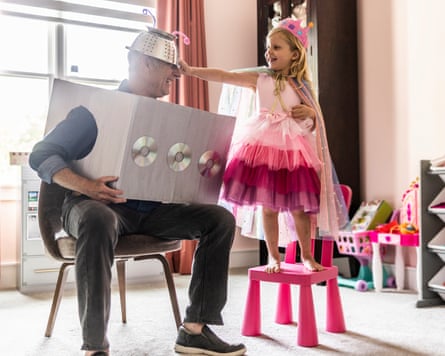 a grandfather and granddaughter dressing up in homemade costumes at home