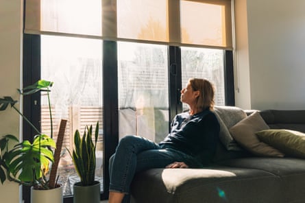 A woman sits on a sofa.