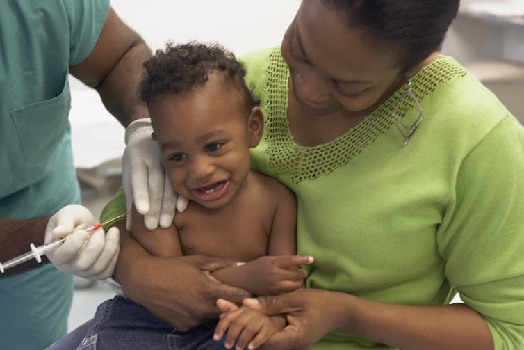 A baby receiving a vaccine at a hospital.