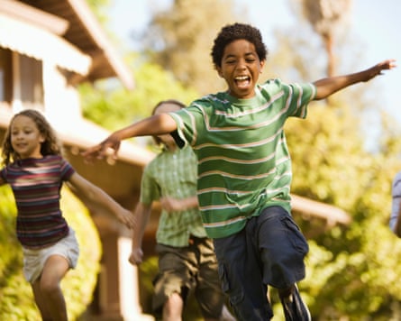 Boy playing outside with friends, arms outstretched