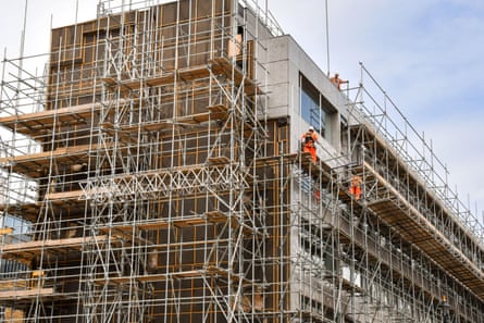 London, England, UK - 27 June 2023: Construction workers standing on scaffolding high above a street in central London.2RD0CRP London, England, UK - 27 June 2023: Construction workers standing on scaffolding high above a street in central London.