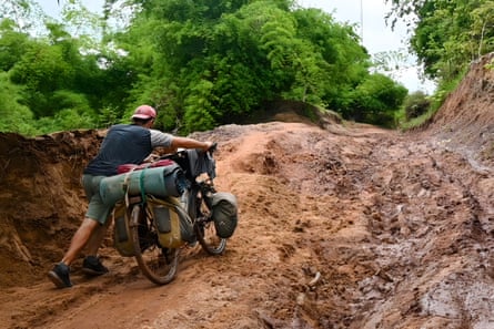 Graf pushes his bike through a landslide