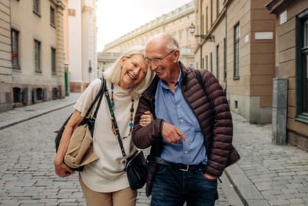 Happy retired senior couple strolling arm in arm on a city street