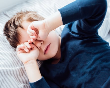 A five-year-old boy rubbing his eyes