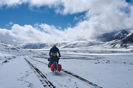 Graf cycles through a snowy mountain scene