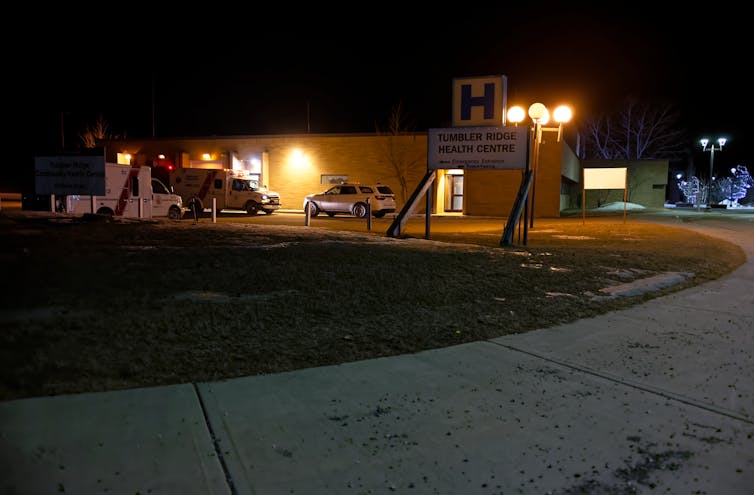 Lights and an ambulance seen behind a sign that says Tumbler Ridge health centre.