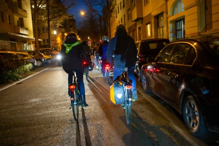 A group of cyclists riding through city streets at night