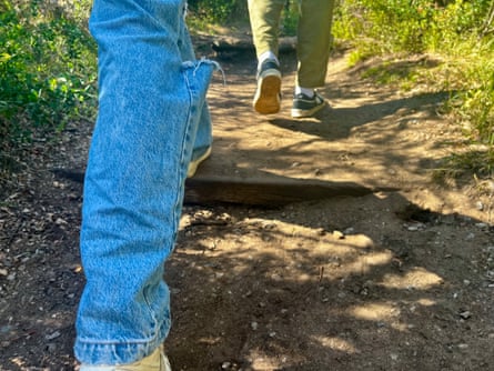 Two people walk in jeans on a bush track