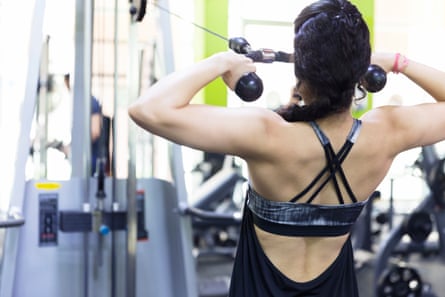 Girl exercising on a cable cross machine at a gym