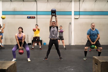 A group of people exercise with kettlebells.