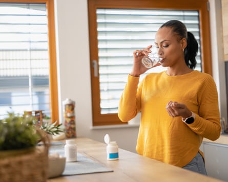 young Woman Taking Medicine With Water at home