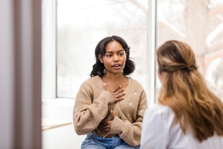 A young woman speaks to a doctor.