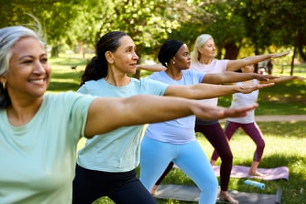 Five women do outdoor yoga.