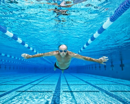 Older man swimming in pool underwater view