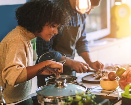 woman cooking, with a bowl of vegetables nearby