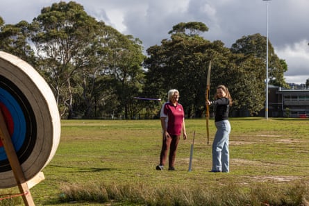 Leaver lets an arrow fly as an instructor looks on