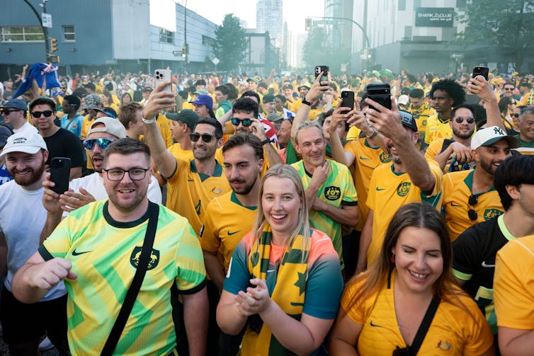 Soccer fans walk in a public space.