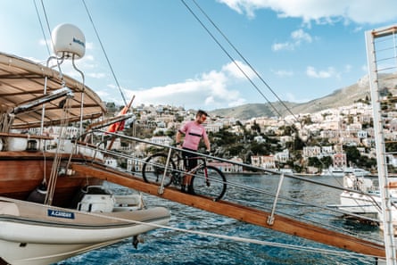 Sam Wood unloading a bike from a gulet, a Turkish wooden sailboat, on Symi in 2023