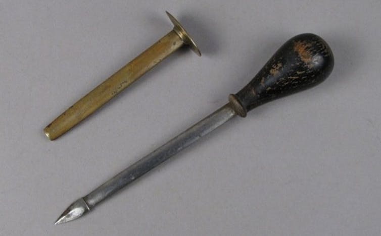 two metal tools side by side, one more like a tube and one with a sharp point