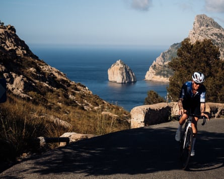 Paddy Maddison cycles uphill on a coastal mountain road overlooking the sea