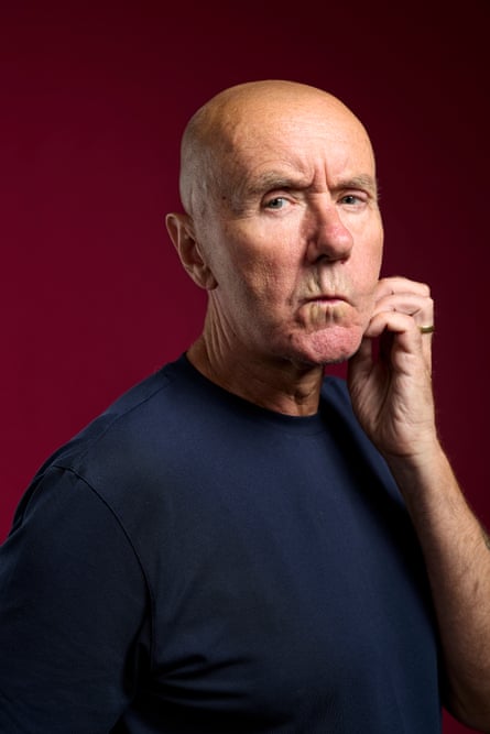 A bald-headed man in a blue jumper looking quizzically at the camera