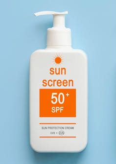 A pump bottle of SPF 50 sunscreen against a blue background