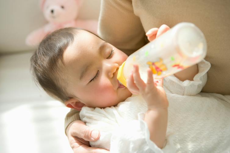 Baby holding a bottle