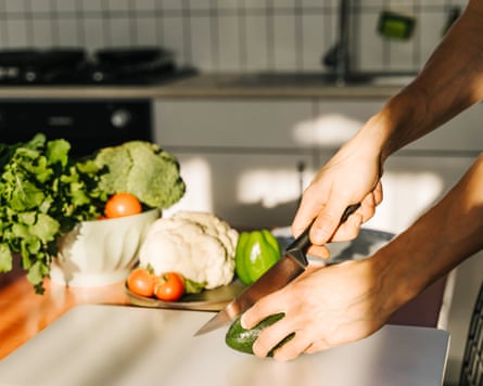 Young man cooking guacamole in kitchen