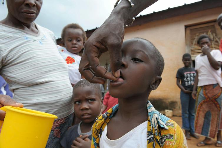 boy being given a pill by an adult