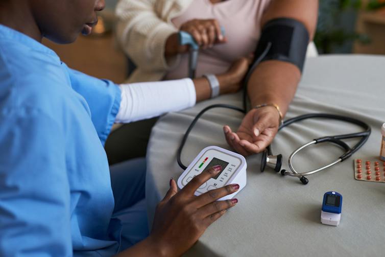 Clinician collecting blood pressure reading from a patient